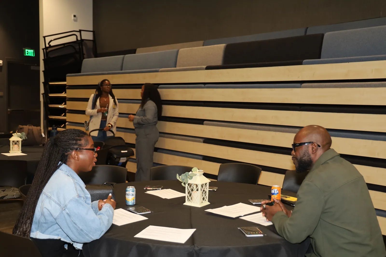 Two people discussing printed notes across a table